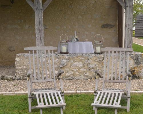two wooden chairs sitting in front of a table at Le Murmure des Fées in Issigeac