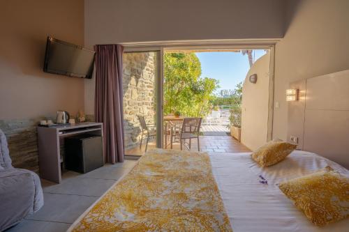 - une chambre avec un lit et une vue sur une terrasse dans l'établissement Hotel Le Grand Pavois, au Lavandou