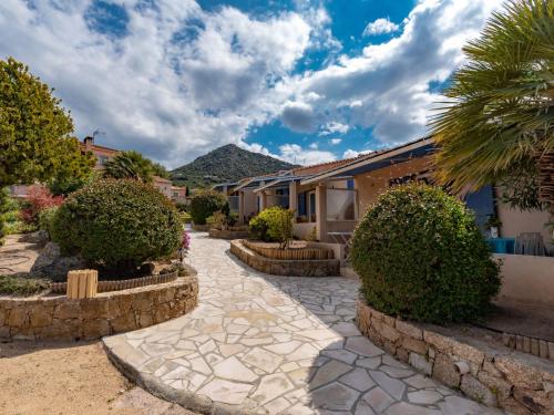 un patio con una pasarela de piedra frente a un edificio en Holiday Home San Antoine - IRU140 by Interhome en LʼÎle-Rousse