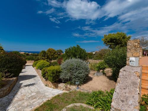 um jardim com um caminho de pedra e arbustos em Holiday Home San Antoine - IRU140 by Interhome em LʼÎle-Rousse