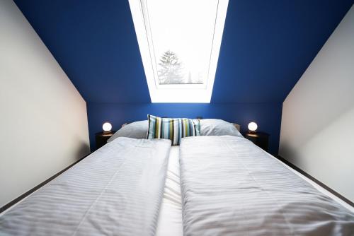 a blue bedroom with two beds and a window at Max Lodging Serviced Apartments in Munich