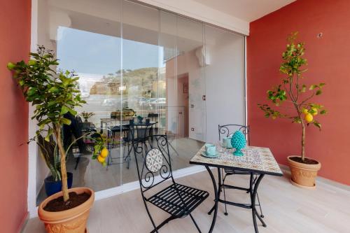 a room with a table and chairs and plants at Maison Lorelle - De Vivo Realty Sorrento in Sorrento
