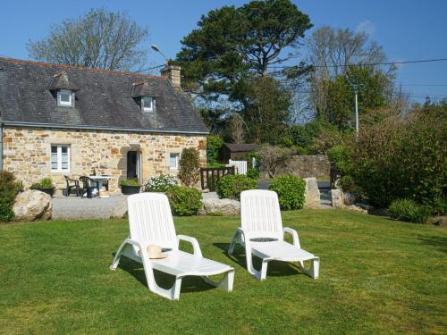 Deux chaises blanches assises sur l'herbe devant une maison dans l'établissement Holiday Home Chez Jeanne by Interhome, à Crozon