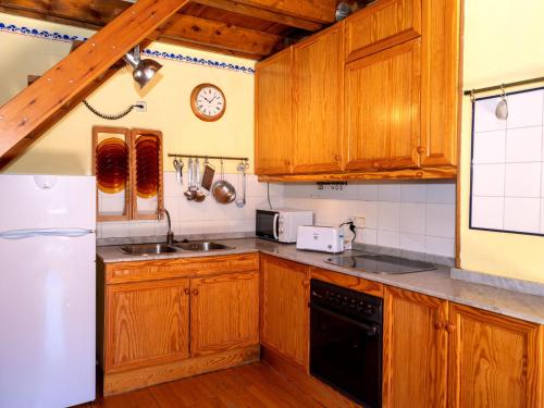 uma cozinha com armários de madeira e um frigorífico branco em Apartment Herbasabina by Interhome em Pla de l'Ermita