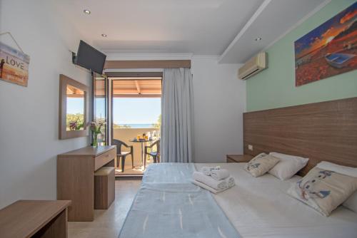 a bedroom with a large bed and a balcony at Zefiros by sea in Laganas