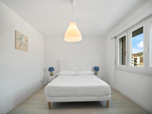 a white bedroom with a white bed and a window at Caslano City Apartments in Caslano