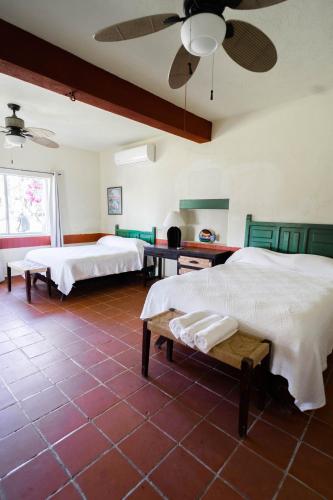 a bedroom with two beds and a ceiling fan at Hotel Rancho Buenavista in Los Barriles