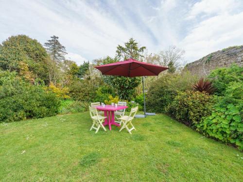 une table et des chaises avec un parasol dans l'herbe dans l'établissement Holiday Home Le Pigeonnier by Interhome, à Roscanvel