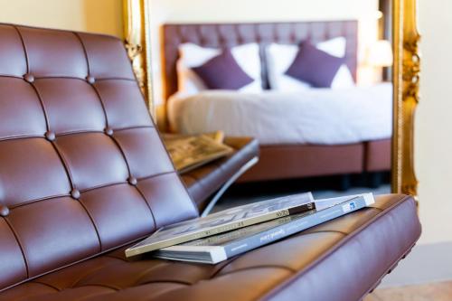 a leather couch with a mirror and a book on it at Boccioleto Resort - Place of Charme in Montaione