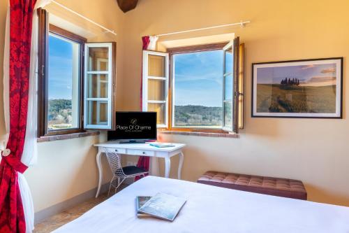 a room with a desk and two windows at Boccioleto Resort - Place of Charme in Montaione