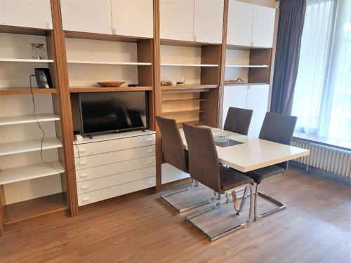 Cette chambre dispose d'une table, de chaises et d'une télévision. dans l'établissement Apartment Schlossalmblick by Interhome, à Bad Hofgastein