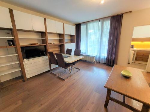 - un salon avec une table, des chaises et un bureau dans l'établissement Apartment Schlossalmblick by Interhome, à Bad Hofgastein