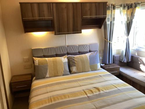 ein Schlafzimmer mit einem Bett mit Kissen darauf in der Unterkunft Luxury caravan at Seton Sands in Port Seton