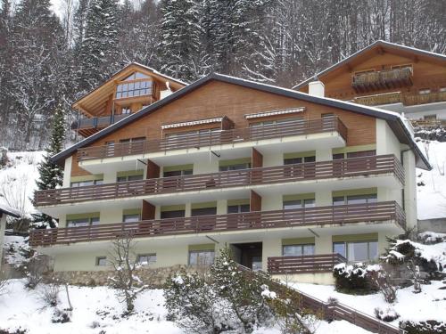 um grande edifício de apartamentos com neve no chão em Apartment Zügstrasse 2- 206 by Interhome em Engelberg