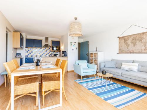 ein Wohnzimmer mit einem Tisch, Stühlen und einem Sofa in der Unterkunft Apartment Les Hautes Folies-5 by Interhome in Saint-Palais-sur-Mer