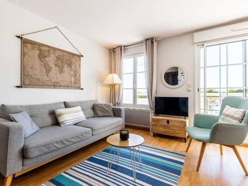 ein Wohnzimmer mit einem grauen Sofa und 2 Stühlen in der Unterkunft Apartment Les Hautes Folies-5 by Interhome in Saint-Palais-sur-Mer