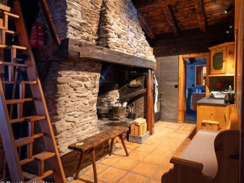 サース・アルマゲルにあるApartment Zer Trächu by Interhomeの石造りの暖炉と木製のはしご付きのキッチン
