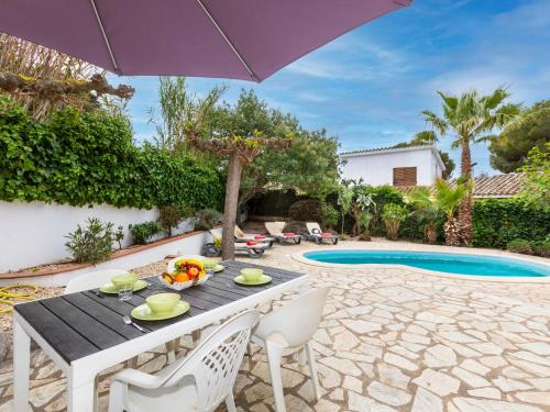 a table and chairs with an umbrella next to a pool at Holiday Home Hamaca by Interhome in Calonge