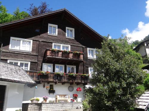 ein schwarzweißes Haus mit Blumen auf den Balkonen in der Unterkunft Apartment Steinacher 7 by Interhome in Engelberg