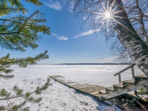 Holiday Home Koivuranta by Interhome في Pohjavaara: مسار خشبي في الثلج مع اشعة الشمس