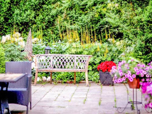 タンペレにあるHoliday Home Pispalan elokuvaranta by Interhomeの花の咲く庭園に座る木製ベンチ