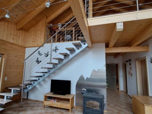 a living room with a staircase and a fireplace at Chalet Dolzer by Interhome in Hochrindl