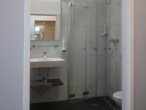 a bathroom with a sink and a shower at Hotel Linde-Sinohaus in Lustenau