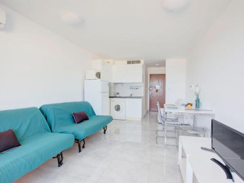 un salon avec un canapé bleu et une table dans l'établissement Studio Vistaéro-7 by Interhome, au Barcarès