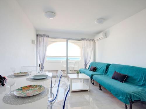 un salon avec un canapé bleu et une table dans l'établissement Studio Vistaéro-7 by Interhome, au Barcarès