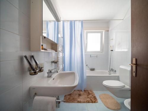 a white bathroom with a sink and a toilet at Caslano City Apartments in Caslano