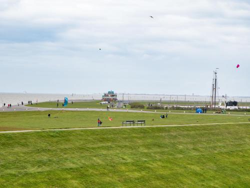 a group of people flying kites at the beach at Holiday Home Reuse by Interhome in Norddeich