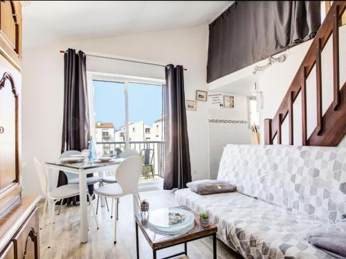 a living room with a bed and a dining room table at Apartment Les Villageoises-2 by Interhome in Le Barcarès