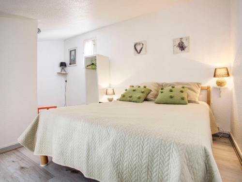 une chambre blanche avec un grand lit avec des oreillers verts dans l'établissement Apartment Les Villageoises-2 by Interhome, au Barcarès