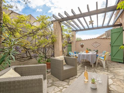 d'une terrasse avec une table, des chaises et une pergola. dans l'établissement Holiday Home Les Cyprès by Interhome, à Hyères