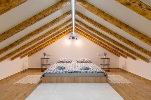 Un dormitorio con una cama en una habitación con techos de madera. en Villa Biokovska, en Podgora