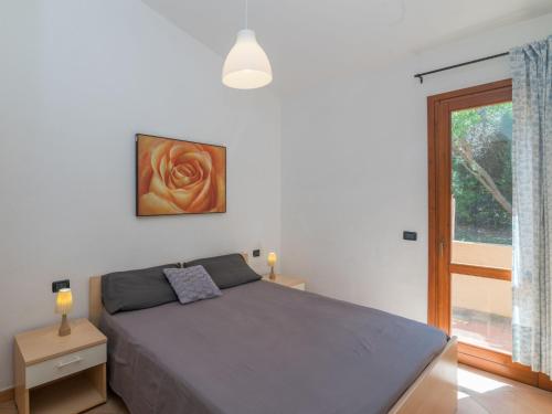 ein Schlafzimmer mit einem Bett und einem Fenster in der Unterkunft Holiday Home Corbezzolo by Interhome in Costa Paradiso