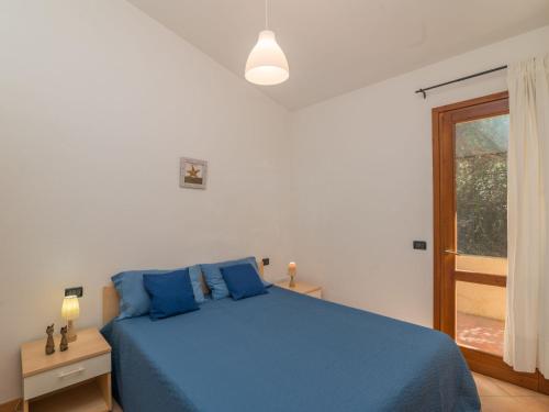 een slaapkamer met een blauw bed en een raam bij Holiday Home Erica by Interhome in Costa Paradiso