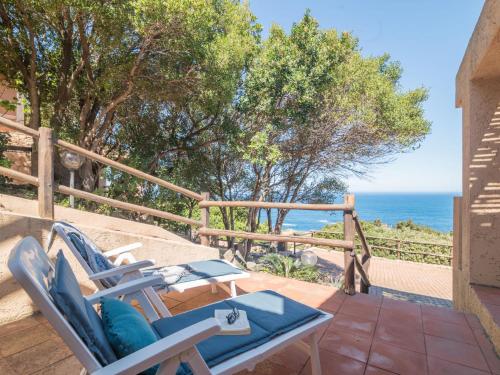 a patio with chairs and the ocean in the background at Holiday Home Li Cossi by Interhome in Costa Paradiso
