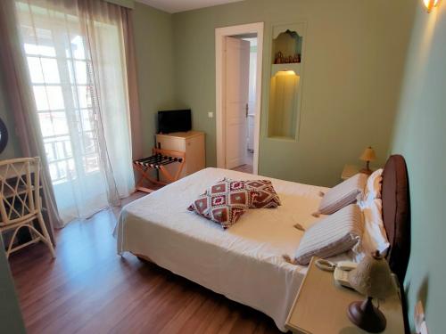een slaapkamer met een bed en een televisie. bij Galini Hotel Agios Ioannis Pelion in Agios Ioannis Pelio