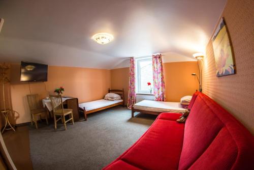 a living room with a red couch and a window at Medainie apartamenti in Liepāja