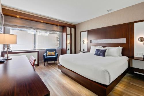 Cette chambre comprend un grand lit et une chaise. dans l'établissement The J House Greenwich Hotel, à Greenwich