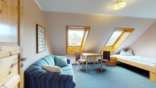 um quarto com um sofá, uma cama e uma mesa em Ferienbauernhof Liesenberg Jagdreihenhaus Hase em Fehmarn