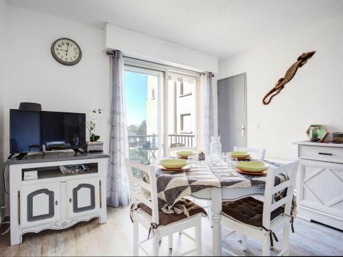 een witte eetkamer met een tafel en een tv bij Apartment Les Villageoises-3 by Interhome in Le Barcarès