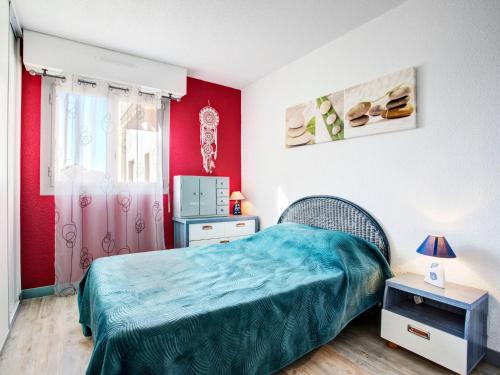 ein Schlafzimmer mit einem Bett und einer roten Wand in der Unterkunft Apartment Les Villageoises-3 by Interhome in Le Barcarès