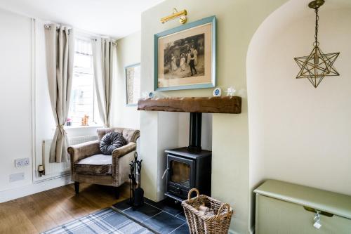 a living room with a wood stove and a chair at Laurel Cottage in Lincolnshire