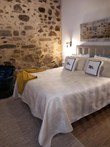 a bedroom with a white bed with two pillows on it at Salgueiral Guest House Douro in Peso da Régua