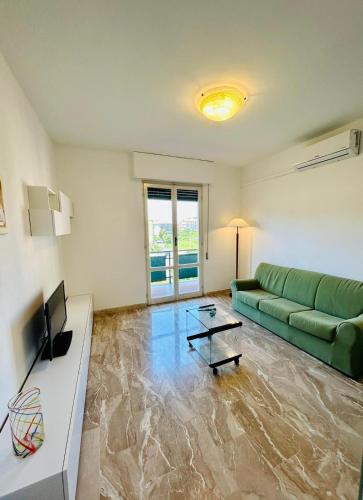 een woonkamer met een groene bank en een televisie bij Casa Bixio in Sestri Levante