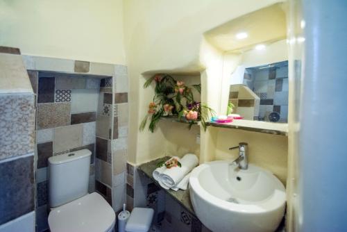 a bathroom with a white toilet and a sink at Two little houses with panorama view in Kýthira