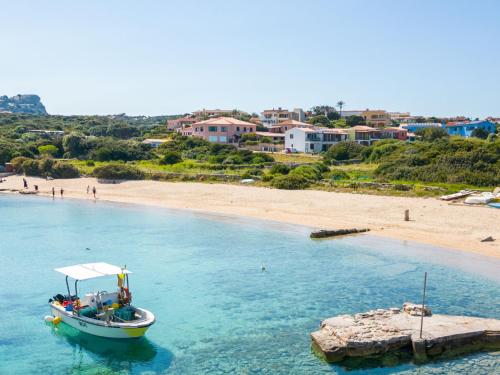 a boat in the water next to a beach at Apartment Capo Testa by Interhome in Capo Testa