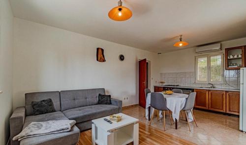 uma sala de estar com um sofá e uma mesa em Kuća “Ule” Postrana em Žrnovo